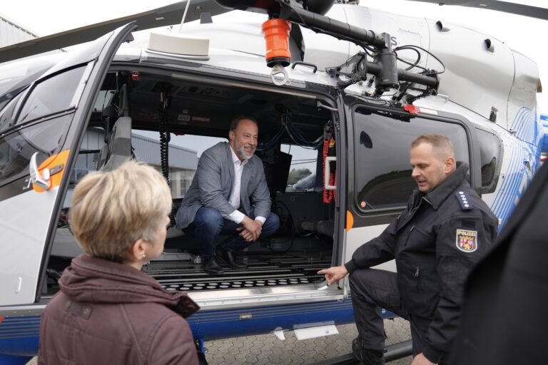Dr. Jan Bollinger (AfD) lässt sich ein Hubschrauber der Landespolizei in Winningen erklären.